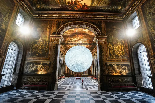 Visitors look at Luke Jerram's “Museum of the Moon” in the , Painted Hall at the Old Royal Naval College, Greenwich on Monday, December 12, 2022. (Photo by Ian West/PA Wire)