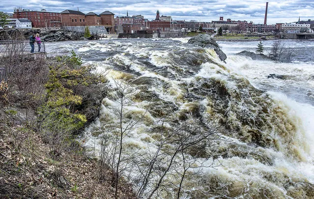 John Knapp and Monica Strobel, from Bowdoin, Me.,stand on the viewing platform at the Lewiston Falls Station Falls recreation area in Auburn and marvel at the height of the water and enjoy the roar of the Androscoggin River on Thursday afternoon, April 25, 2019. (Photo by Andree Kehn/Sun Journal via AP Photo)