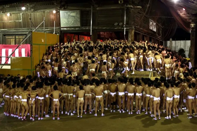 In this picture taken on February 18, 2017, worshippers wait for the priest to throw the sacred batons during the annual Naked Man Festival or “Hadaka Matsuri” at Saidaiji Temple in Okayama, western Japan With only a skimpy loincloth to protect their modesty, thousands of men brave freezing temperatures to fight for lucky charms thrown by a priest at Japan' s annual Naked Man Festival. (Photo by Behrouz Mehri/AFP Photo)