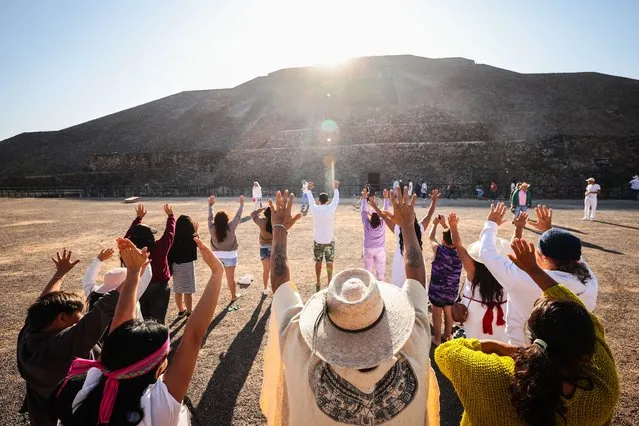 A group of people raise their arms to draw energy from the sun during the celebrations for the Spring Equinox on March 21, 2024 at the Pre-Hispanic City of Teotihuacan, Mexico. (Photo by Hector Vivas/Getty Images)