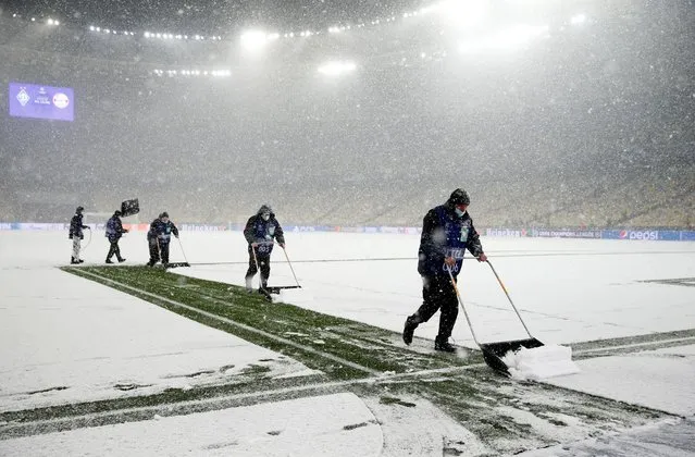 Snow is cleared from the pitch at Dynamo Kiev before a Champions League match against Bayern Munich at NSC Olympiyskiy in Kyiv, Ukraine on November 23, 2021. The German visitors didn’t slip up in the freezing weather, winning the game 2-1. (Photo by Valentyn Ogirenko/Reuters)