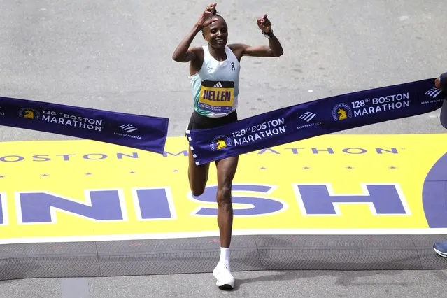 Hellen Obiri, of Kenya, raises her arms as she wins the women's division at the Boston Marathon, Monday, April 15, 2024, in Boston. (Photo by Charles Krupa/AP Photo)