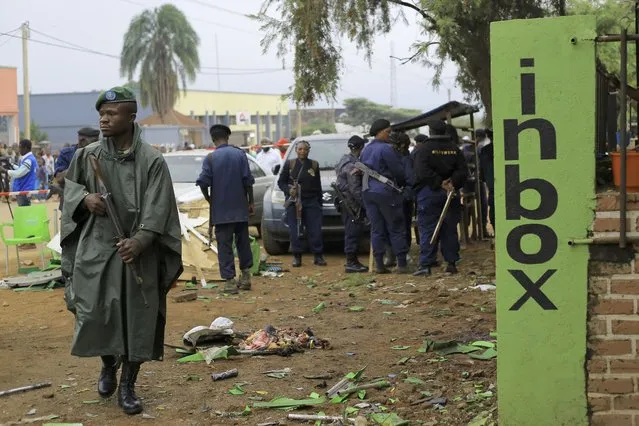 Police officers inspect the scene of a bombed explosion in Beni, eastern Congo Sunday December 26, 2021. A bomb exploded at a restaurant Saturday as patrons gathered on Christmas Day in an eastern Congolese town where Islamic extremists are known to be active. (Photo by Al-hadji Kudra Maliro/AP Photo)