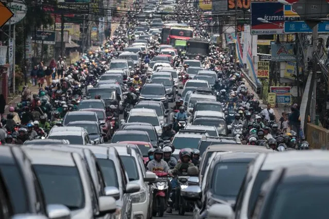 Cars and motorcycles occupy a road on the weekend of the Eid al-Fitr holiday, celebrating the end of the Muslim holy fasting month of Ramadan, in Bogor, West Java on April 13, 2024. (Photo by Aditya Aji/AFP Photo)