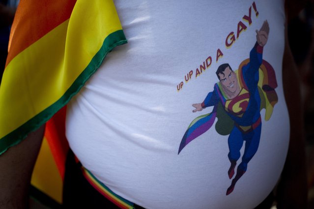 A man wears a t-shirt depicting a gay superhero at the annual Gay Pride Parade in Tel Aviv, Israel, Friday, June 12, 2015. Thousands of bare-chested muscular men, drag queens in heavy makeup and high heels, women in colorful balloon costumes and others partied at Tel Aviv's annual gay pride parade on Friday, the largest event of its kind in the region. (AP Photo/Ariel Schalit)