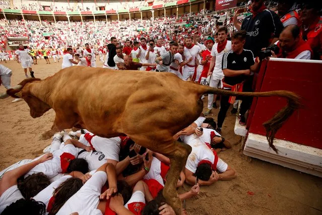 A wild cow leaps over revellers during the running of the bulls at the San Fermin festival in Pamplona, Spain, July 9, 2019. (Photo by Susana Vera/Reuters)
