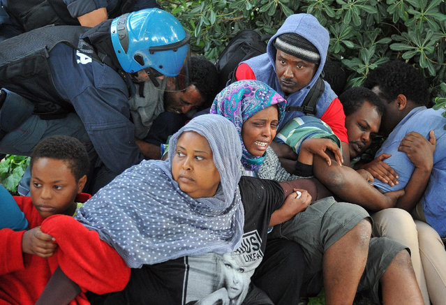 Italian Police remove migrants in Ventimiglia, at the Italian-French border Tuesday, June 16, 2015. Police at Italy's Mediterranean border with France have forcibly removed some of the African migrants who have been camping out for days in hopes of continuing their journeys farther north. The migrants, mostly from Sudan and Eritrea, have been camped out for five days after French border police refused to let them cross. (Luca Zennaro/ANSA via AP)