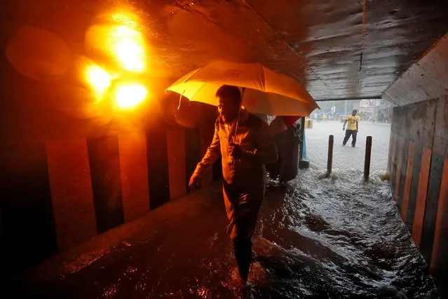 A commuter walks in a flooded underpass during heavy rains in Mumbai, India, July 8, 2019. (Photo by Francis Mascarenhas/Reuters)