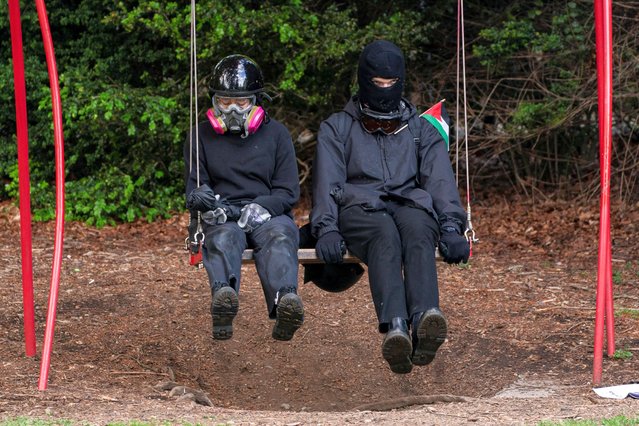 Protesters watch while sitting on a swing as attendees enter Turning Point USA founder and conservative commentator Charlie Kirk’s speech on campus near a protest encampment of supporters of Palestinians in Gaza, during the ongoing conflict between Israel and the Palestinian Islamist group Hamas, at the University of Washington in Seattle, Washington, U.S. May 7, 2024. (Photo by David Ryder/Reuters)