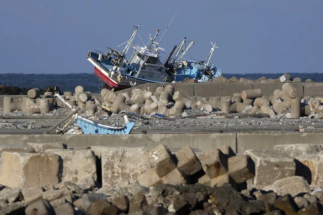 A fishing vessel swept ashore by the tsunami following the March 2011 earthquake sits abandoned on a breakwater in Namie, Fukushima Prefecture, Japan, on Monday, March 11, 2014. March 11 marks three years since Japan's deadliest earthquake in 2011, a magnitude-9 temblor that triggered a tsunami in northeastern Japan, leaving about 19,000 people dead or missing and hundreds of thousands homeless as it wiped out entire towns. (Photo by Kiyoshi Ota/Bloomberg)