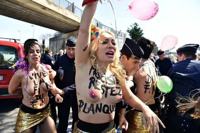 Inna Shevchenko (C) and other topless Femen activists protest outside a banquet held by France's far-right Front National (FN) party in honour of Jeanne d'Arc (Joan of Arc) at the Porte de La Villette in Paris on May 1, 2016. (Photo by Alain Jocard/AFP Photo)