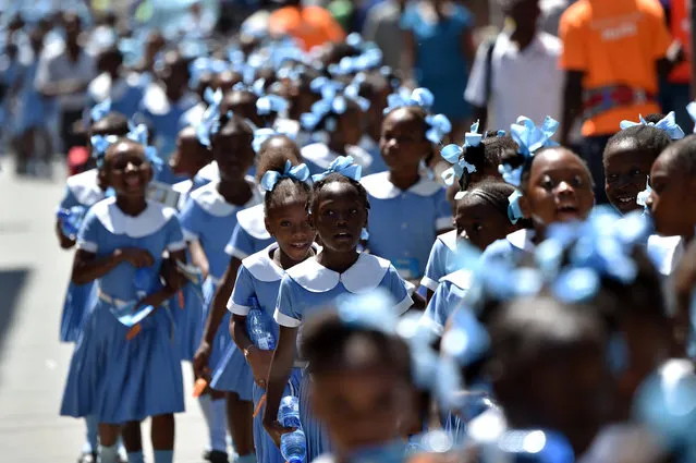 Haitian students walk as they head to a security zone during an Earthquake and Tsunami Emergency drill in the city of Cap-Haitien, on May 6, 2016. The simulation exercise was organised by the Civil Protection Directorate, with the support of the UN Development Programme (UNDP). An estimated 4,500 people participated in the activities during the simulacre. (Photo by Hector Retamal/AFP Photo)