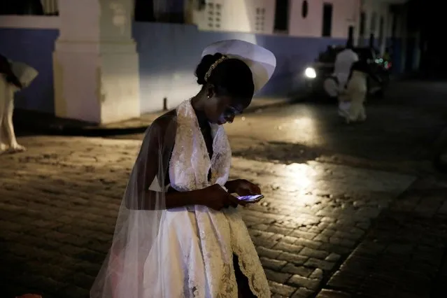 A hostess checks her phone after 2019 Haiti Diner en Blanc event in Cap Haitien, Haiti, August 10, 2019. (Photo by Andres Martinez Casares/Reuters)