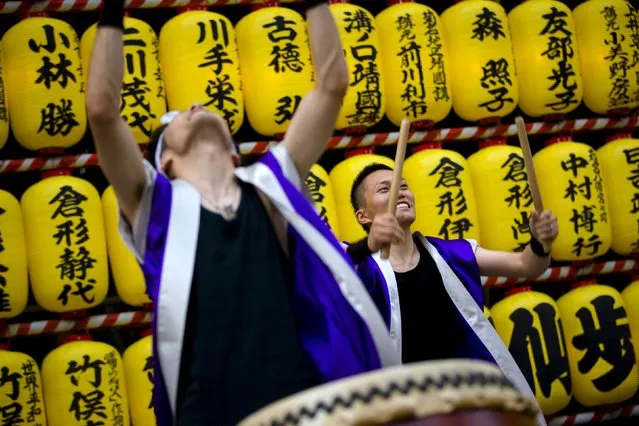 Men play drums in front of a wall of lanterns during the annual Mitama Festival at the Yasukuni Shrine in Tokyo, Japan, July 13, 2015. (Photo by Thomas Peter/Reuters)