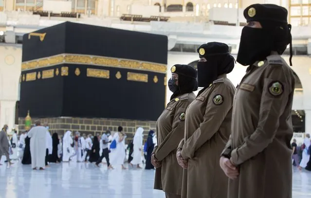 In this July 20, 2021 photo, Saudi police women, who were recently deployed to the service, from right to left, Samar, Alaa, and Bashair, stand alert in front of the Kaaba, the cubic building at the Grand Mosque, during the annual hajj pilgrimage in the Saudi Arabia's holy city of Mecca. The cloud of social restrictions that loomed over generations of Saudis is quickly dissipating and the country is undergoing visible change. Still, for countless numbers of people in the United States and beyond, Saudi Arabia will forever be associated with 9/11. (Photo by Amr Nabil/AP Photo)
