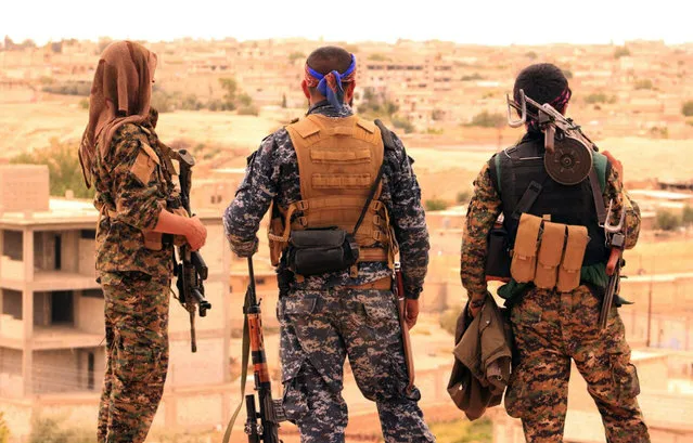 This Sunday, April 30, 2017 photo provided by the Syrian Democratic Forces (SDF), shows fighters from the SDF looking toward the northern town of Tabqa, Syria. U.S.-backed opposition fighters led by Syrian Kurdish forces captured more territory from the Islamic State group in the northern town of Tabqa on Monday, pushing the extremists to northern neighborhoods, close to one of Syria's largest dams. (Photo by Syrian Democratic Forces via AP Photo)