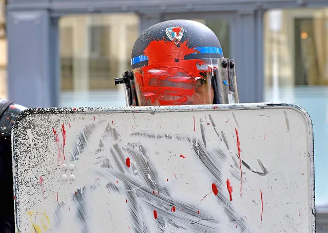 French riot police officers stand guard after receiving some paint on their uniform, during a demonstration to protest against the government's labour reform on May 19, 2016 in Bordeaux. France was disrupted by a third straight day of strikes and demonstrations on May 19 as the prime minister called for protesters who torched a police car to face “harsh” punishment. The labour reforms have sparked two months of protests on France's streets, drawing 68,000 nationwide on Tuesday, police said, while organisers put the turnout at 220,000. (Photo by Georges Gobet/AFP Photo)