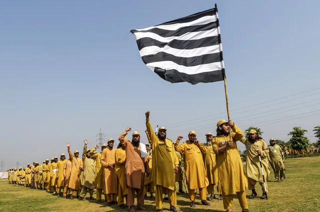 Activists of Jamiat Ulema-e Islam Fazal (JUI-F) party raise hands as they prepare an “Azadi” (freedom) march in Peshawar on October 13, 2019. JUI-F chief Maulana Fazal-ur-Rehman had announced that the party will begin its anti-government “Azadi March” on October 27. (Photo by Abdul Majeed/AFP Photo)