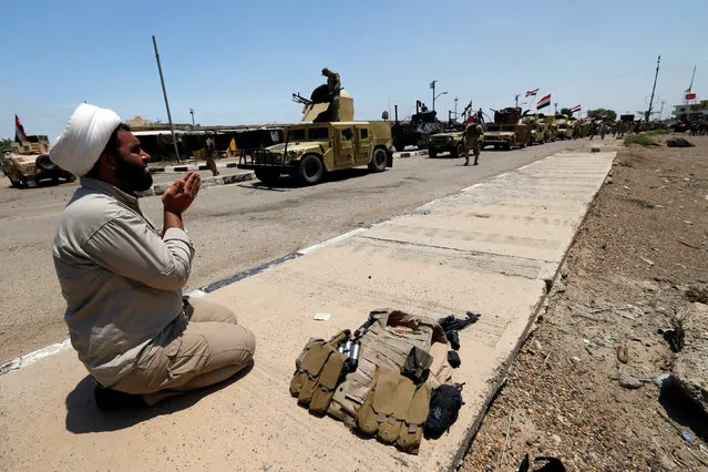 An Iraqi Shi'ite fighter prays as he celebrates victory in the town of Garma, Iraq, May 26, 2016. (Photo by Thaier Al-Sudani/Reuters)