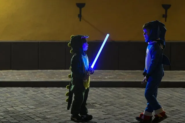 Children wearing costumes play with a toy lightsaber as Romania's Jewish community celebrates Purim at the Coral Temple synagogue in Bucharest, Romania, Wednesday, March 16, 2022. Romanian Jews dedicated the Purim 5782 celebration to the Ukrainian people, praying for an end to war. (Photo by Andreea Alexandru/AP Photo)