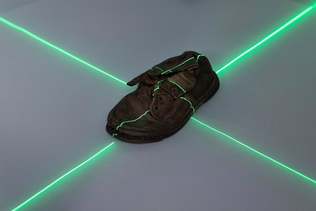 A shoe that belonged to a child victim of the former Nazi German death camp Auschwitz-Birkenau is scanned at the conservation laboratory on the grounds of the camp in Oswiecim, Poland, Wednesday, May 10, 2023. Most of the victims were Jews killed in dictator Adolf Hitler's attempt to exterminate the Jews of Europe. (Photo by Michal Dyjuk/AP Photo)