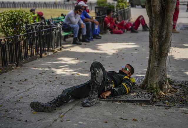 A rescue worker recuperates after searching through the rubble of the destroyed five-star Hotel Saratoga days after a deadly explosion in Old Havana, Cuba, Tuesday, May 10, 2022. (Photo by Ramon Espinosa/AP Photo)