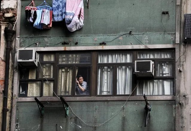 A woman looks out of a window during an anti-government protest in Hong Kong, October 20, 2019. (Photo by Ammar Awad/Reuters)