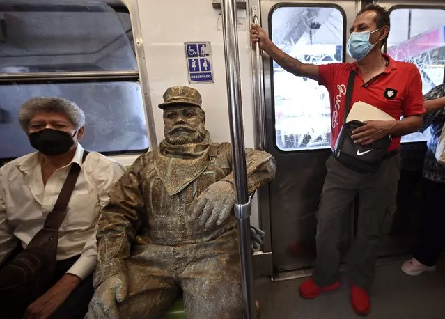 Mexican urban artist Miguel Moctezuma, aka “Don Ferro Ferrocarrilero”, goes from one subway station to another during his performance disguised as a railroad worker, in Mexico City on June 6, 2022. Moctezuma, who pays tribute to one of his grandfathers who worked on trains, plans to participate in the Amsterdam Street Art festival in September. (Photo by Alfredo Estrella/AFP Photo)