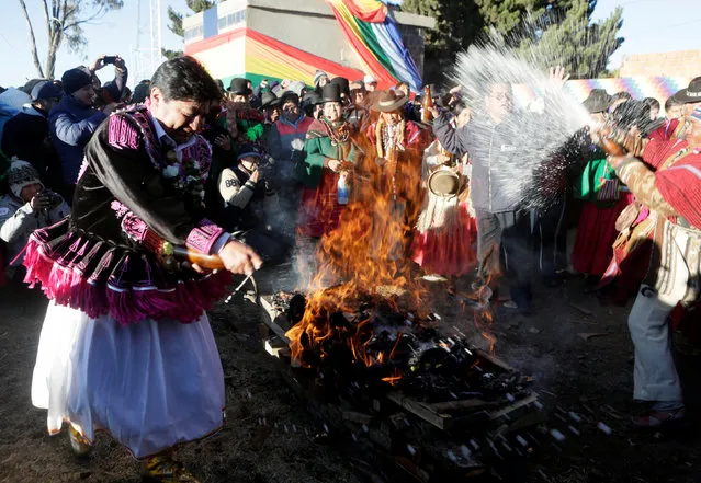 Bolivian indigenous people spray beer on an offering during Aymara New Year ceremony in El Alto near La Paz, Bolivia, June 21, 2016. (Photo by David Mercado/Reuters)