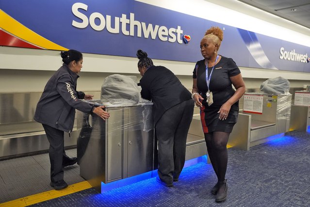 Southwest Airlines employees cover the ticket counters with plastic wrap just before Tampa International Airport was closing due to the possible arrival of Hurricane Milton Tuesday, October 8, 2024, in Tampa, Fla. (Photo by Chris O'Meara/AP Photo)