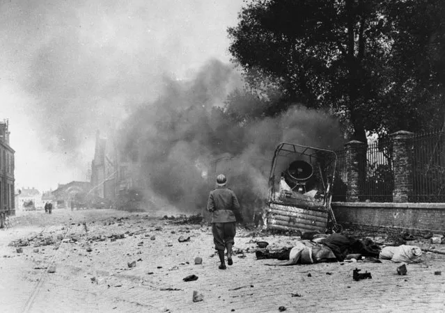 Smoke and debris in a street of Dunkirk, France, showing the effects of bombardment, June 1940. (Photo by AP Photo)