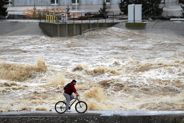 A man cycles near elevated water levels from the river Nysa Klodzka at Glebinow hydroelectric power plant in Nysa, Poland on September 15, 2024. (Photo by Agencja Wyborcza.pl/Lukasz Cynalewski via Reuters)