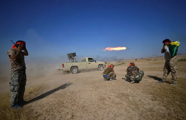 Shi'ite Popular Mobilization Forces (PMF) launch a rocket towards Islamic State militants on the outskirts of Tal Afar, Iraq, August 22, 2017. (Photo by Reuters/Stringer)