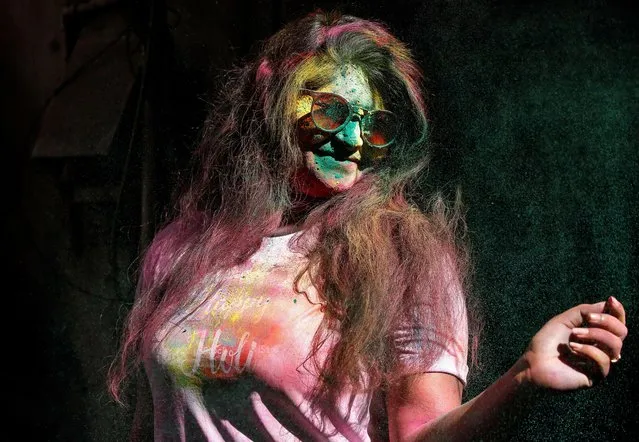A woman with her face daubed in colours dances during Holi celebrations in Chennai, India, March 10, 2020. (Photo by P. Ravikumar/Reuters)