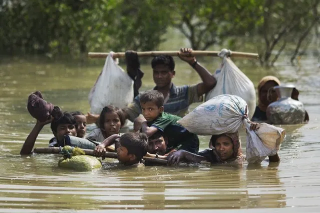 A Rohingya family reaches the Bangladesh border after crossing a creek of the Naf river on the border with Myanmmar, in Cox's Bazar's Teknaf area, Tuesday, September 5, 2017. (Photo by Bernat ArmangueAP Photo)