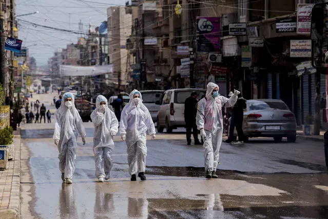 Medical workers oversee the disinfection of the streets to prevent the spread of coronavirus in Qamishli, Syria, Tuesday, March 24, 2020. (Photo by Baderkhan Ahmad/AP Photo)