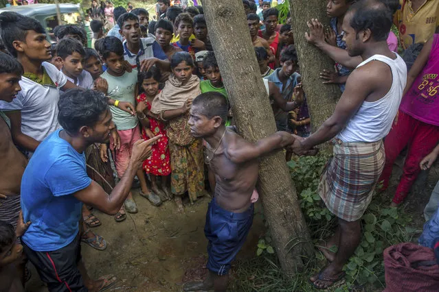 Rohingya Muslims, who recently crossed over from Myanmar into Bangladesh, interrogate a suspected child trafficker near Balukhali refugee camp, Bangladesh, Friday, September 15, 2017. Thousands of Rohingya are continuing to stream across the border, with U.N. officials and others demanding that Myanmar halt what they describe as a campaign of ethnic cleansing that has driven nearly 400,000 Rohingya to flee in the past three weeks. (Photo by Dar Yasin/AP Photo)