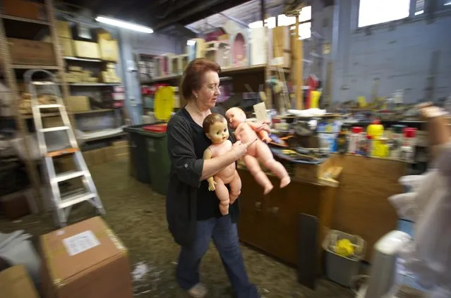 Australian doll repairer Kerry Stuart, a 25-year veteran at Sydney's Doll Hospital, carries spare dolls to be used for parts in repairing customer's dolls, July 15, 2014. (Photo by Jason Reed/Reuters)