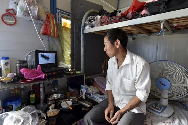 A migrant worker watches a live broadcast of a military parade marking the 70th anniversary of the end of World War Two, at his dormitory in Hefei, Anhui province, China, September 3, 2015. (Photo by Reuters/Stringer)