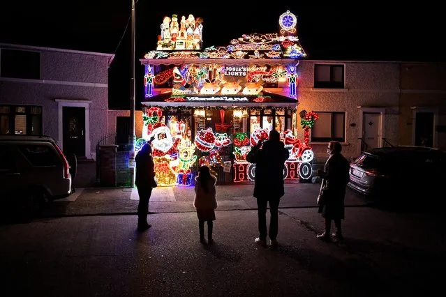 People look at a residential house illuminated with Christmas lights, in Dublin, Ireland, December 21, 2021. (Photo by Clodagh Kilcoyne/Reuters)