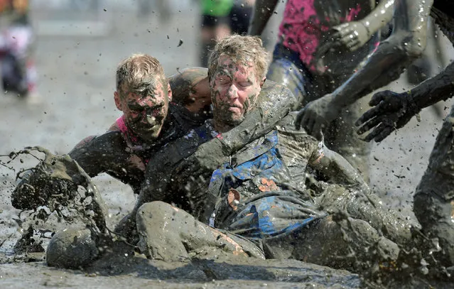 Participants fight for the ball during a handball match at the so called “Wattoluempiade” (Mud Olympics) in Brunsbuettel at the North Sea, Germany July 30, 2016. (Photo by Fabian Bimmer/Reuters)