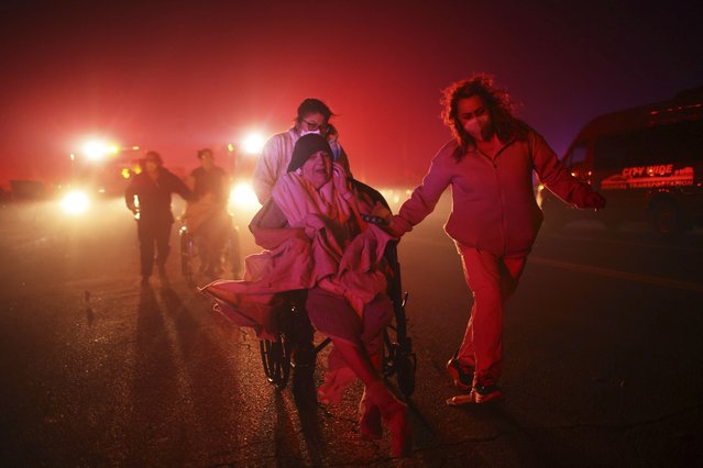 Residents of a senior center are evacuated as the Eaton Fire approaches Tuesday, January 7, 2025 in Altadena, Calif. (Photo by Ethan Swope/AP Photo)