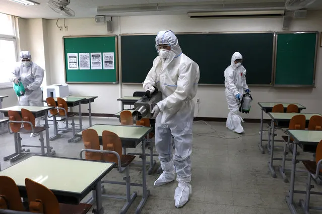 Disinfection professional and government official wearing protective clothing spray anti-septic solution at classroom to prevent the spread of the coronavirus (COVID-19) ahead of school re-opening on May 11, 2020 in Seoul, South Korea. South Korea's education ministry announced plans to re-open schools starting from May 13, more than two months after schools were closed in a precautionary measure against the coronavirus. Coronavirus cases linked to clubs and bars in Seoul's multicultural district of Itaewon have jumped to 54, an official said Sunday, as South Korea struggles to stop the cluster infection from spreading further. According to the Korea Center for Disease Control and Prevention, 35 new cases were reported. The total number of infections in the nation tallies at 10,909. (Photo by Chung Sung-Jun/Getty Images)