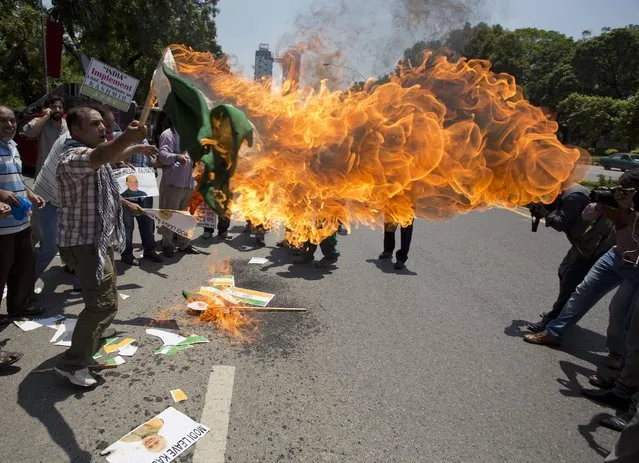 Kashmiris burn a representation of an Indian flag as they chant slogans outside the Foreign Office in Islamabad, Pakistan, Thursday, August 4, 2016. People have rallied in the capital against the imminent visit of India's Interior Minister Rajnath Singh to attend the SAARC organization meeting. (Photo by B.K. Bangash/AP Photo)