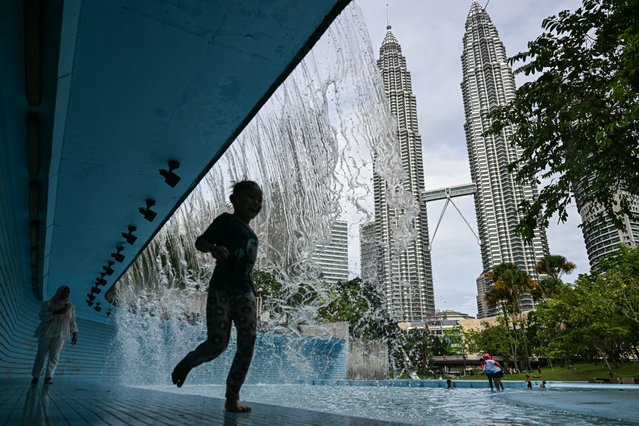 A child plays at a public pool in front of Malaysia's Petronas Twin Towers in Kuala Lumpur on November 28, 2024. (Photo by Mohd Rasfan/AFP Photo)