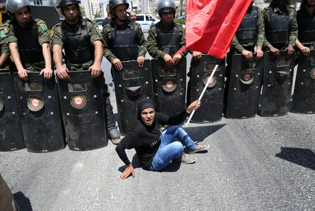 A Palestinian protester sits in front of national security force members during a protest in support of Palestinian prisoners on hunger strike in Israeli jails in the West Bank city of Ramallah August 9, 2016. (Photo by Mohamad Torokman/Reuters)