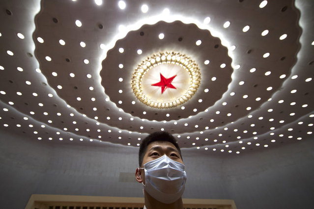 A Chinese security official wearing a face mask stands guard after the opening session of China's National People's Congress (NPC) at the Great Hall of the People in Beijing, Friday, May 22, 2020. (Photo by Ng Han Guan/AP Photo/Pool)