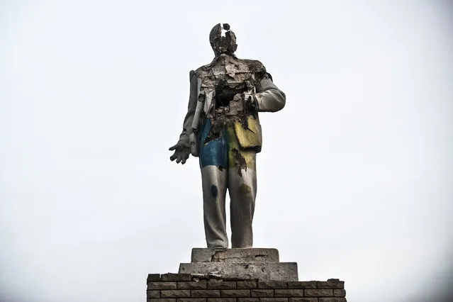 In this photo taken on Thursday, December 10, 2015, a damaged statue of Vladimir Lenin stands in Debaltseve, Ukraine. The Ukrainian Army shot up the statue for target practice while it occupied the town, sieged by separatist rebels who captured it in February 2015 at the end of one of the most devastating battles during the conflict in Ukraine's east. (Photo by Evgeniy Maloletka/AP Photo)