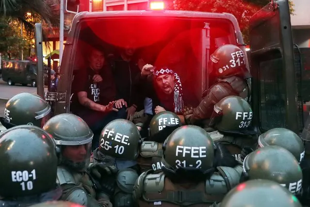Mapuches protesters are arrested by police during a demonstration to demand justice for Brandon Hernandez Huentecol, a 17-year-old Mapuche youth whom a Carabineros national police officer allegedly shot in the back in December 2016 in southern Chile and which left him seriously injured, in Santiago, Chile, 06 November 2017. The protest, attended by about two hundred people and convened by various Mapuche organizations, sought that the alleged shooter, the second sergeant of Carabineros Cristian Rivera, answers before the court. (Photo by Mario Ruiz/EPA/EFE)
