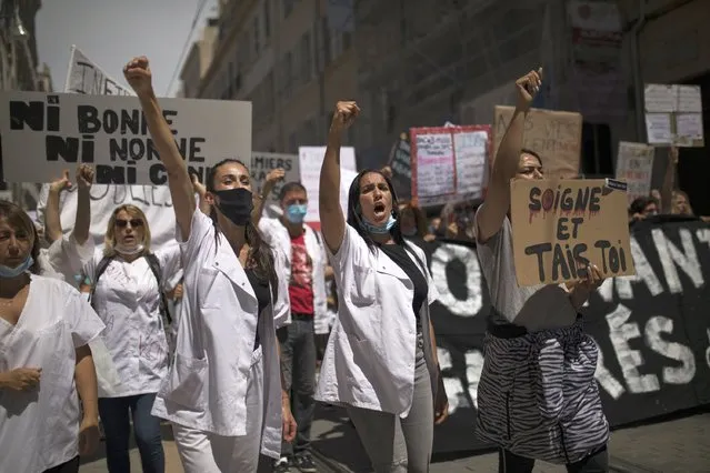 Medical workers chant slogans during a demonstration in Marseille, southern France, Tuesday, June 16, 2020. French hospital workers and others are protesting in cities around the country to demand better pay and more investment in France's public hospital system, which is considered among the world's best but struggled to handle a flux of virus patients after years of cost cuts. France has seen nearly 30,000 virus deaths. (Photo by Daniel Cole/AP Photo)